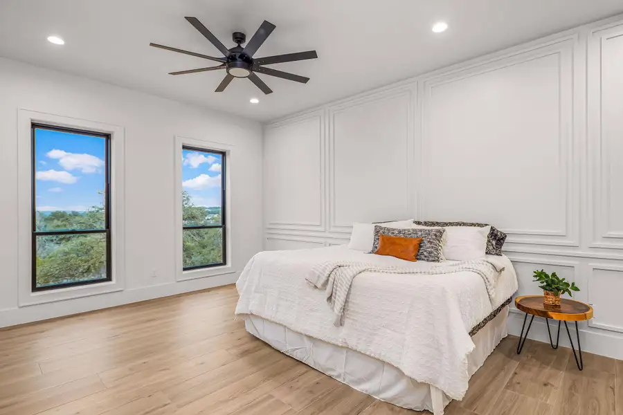 Bedroom featuring a ceiling fan, recessed lighting, a decorative wall, and light wood finished floors