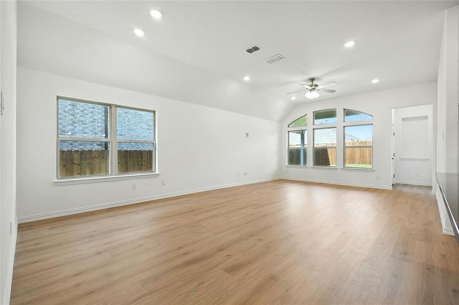 Empty room with a ceiling fan, recessed lighting, light wood-type flooring, and vaulted ceiling