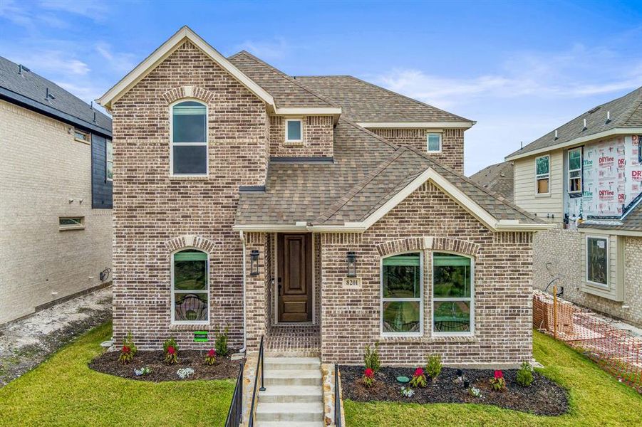 View of front facade featuring a shingled roof, brick siding, and a front yard View of front facade featuring a shingled roof, brick siding, and a front yard