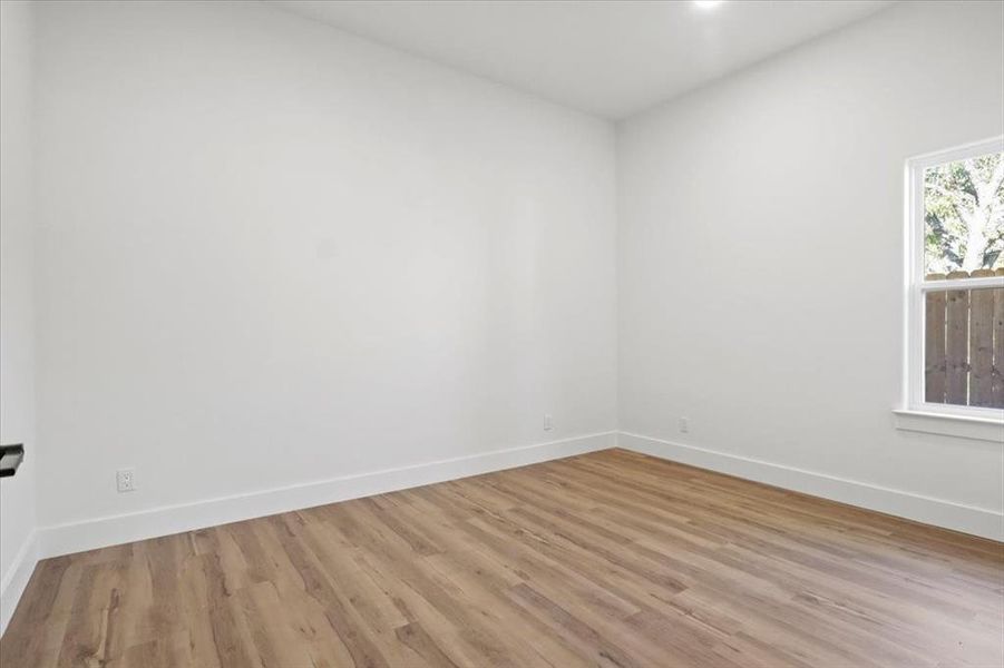 Empty room featuring light wood-style floors and recessed lighting