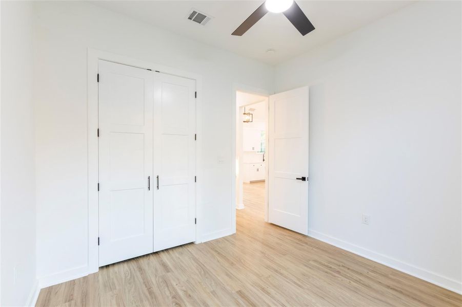 Bedroom three features French doors leading to the closet.