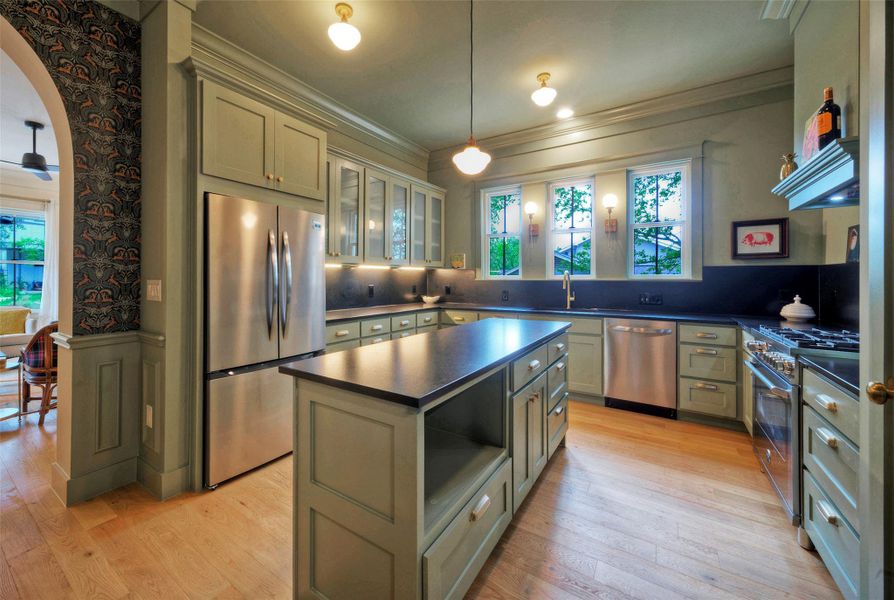 A well-appointed kitchen features stainless steel appliances, custom cabinetry, and a central island with ample counter space.