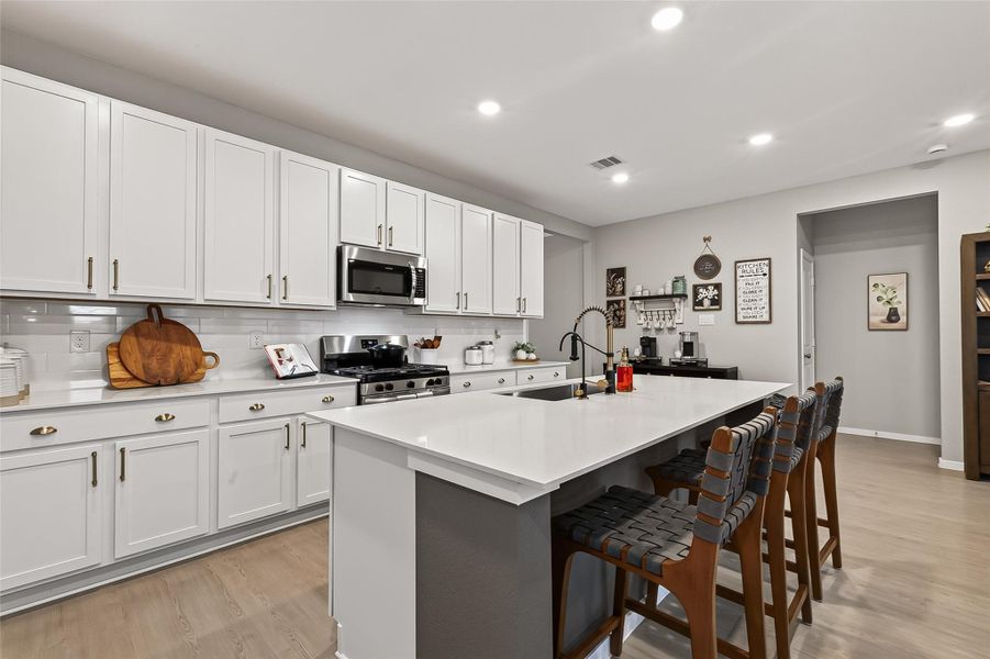 Bright kitchen with center island, breakfast bar seating, and ample cabinetry. Bright kitchen with center island, breakfast bar seating, and ample cabinetry.