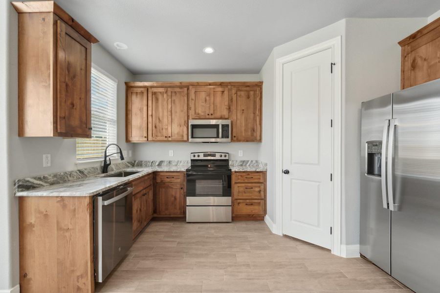 Kitchen featuring a sink, recessed lighting, brown cabinets, and stainless steel appliances