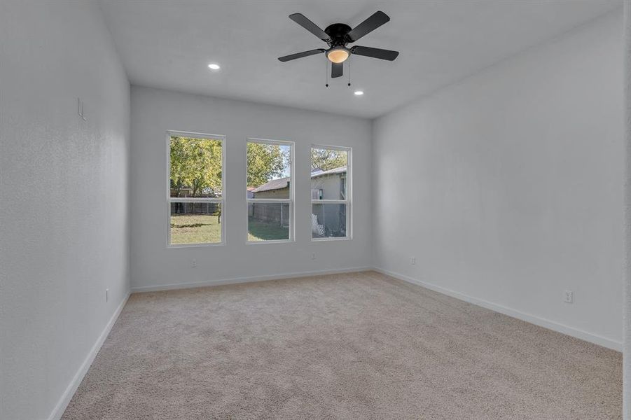 Carpeted spare room with ceiling fan