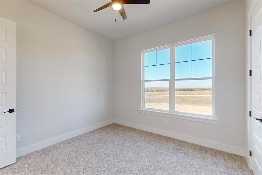 Unfurnished room with ceiling fan and light colored carpet