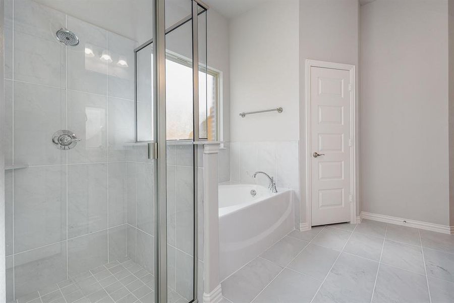 Bathroom with tile patterned floors and shower with separate bathtub