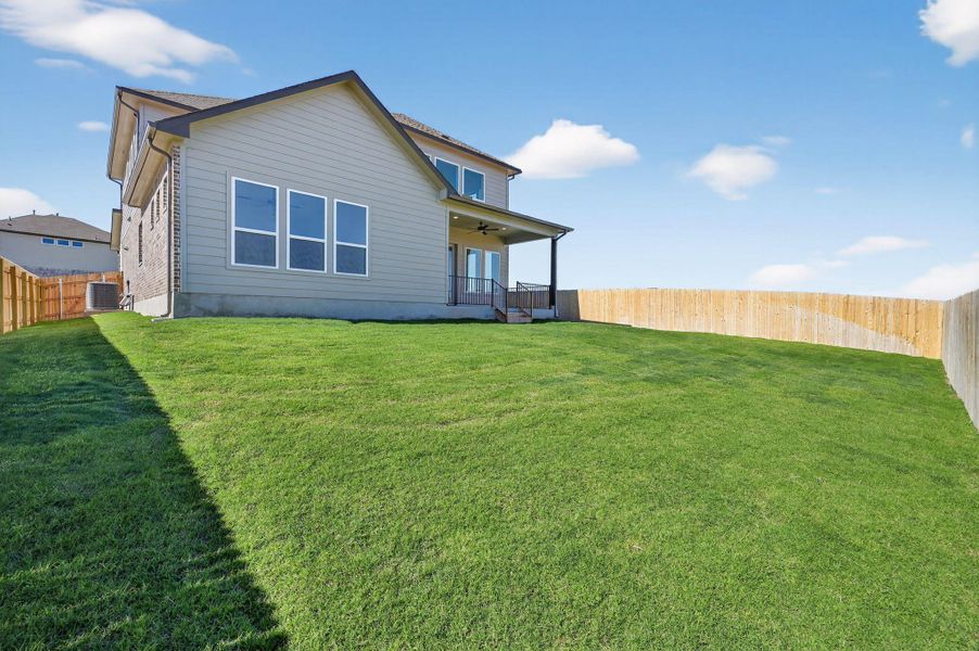 Rear view of house with a fenced backyard, a ceiling fan, and a porch