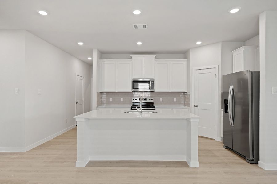 A kitchen with white cabinets.