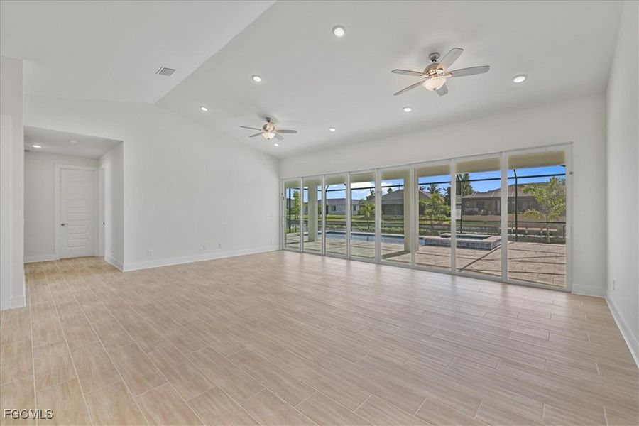 Unfurnished room with recessed lighting, lofted ceiling, wood finish floors, and ceiling fan