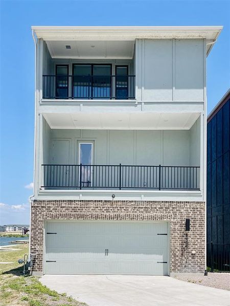 View of front of property with a balcony, brick siding, concrete driveway, and a garage View of front of property with a balcony, brick siding, concrete driveway, and a garage