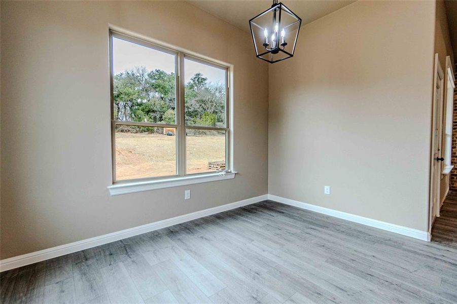 Unfurnished dining area with an inviting chandelier and wood-type flooring