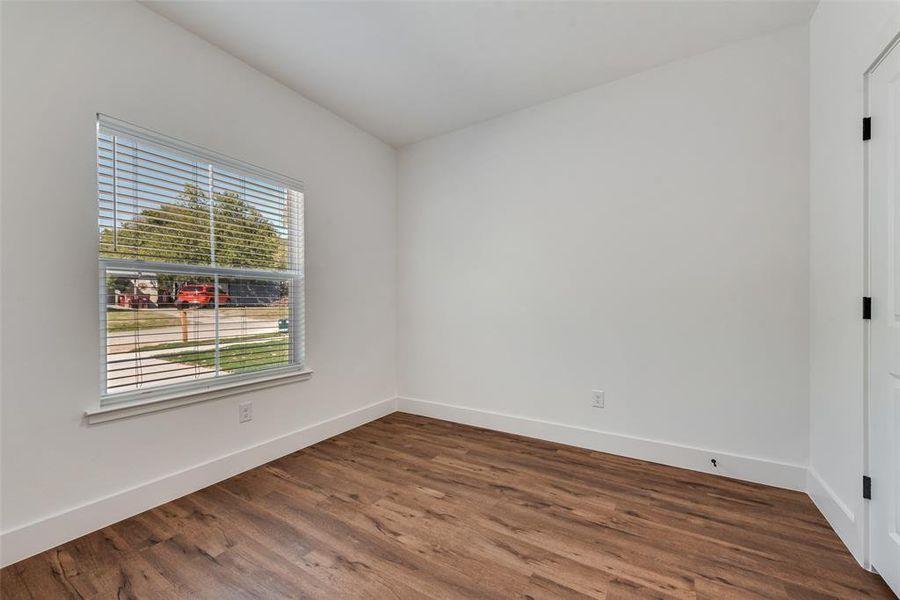 Empty room featuring baseboards and dark wood-style flooring Empty room featuring baseboards and dark wood-style flooring