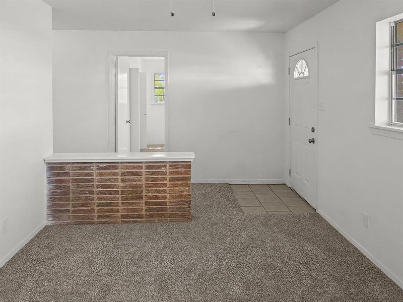 Tiled foyer with carpeted sitting room (could be 3rd bed) and decorative brick half wall Tiled foyer with carpeted sitting room (could be 3rd bed) and decorative brick half wall