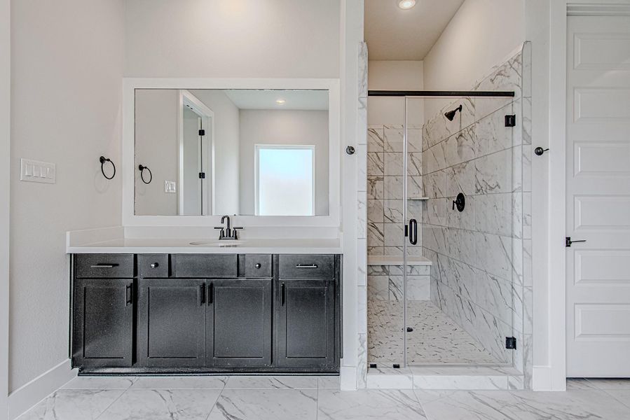 Walk-in shower with modern tile finishes and glass enclosure.
