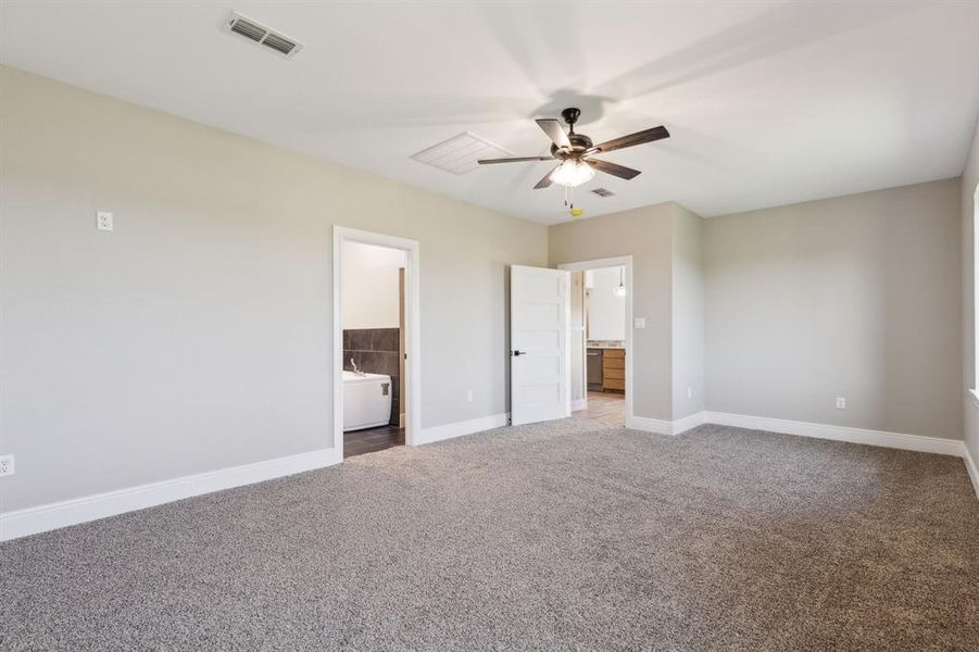 Primary bedroom featuring ensuite bathroom, baseboards, carpet, and a ceiling fan Primary bedroom featuring ensuite bathroom, baseboards, carpet, and a ceiling fan