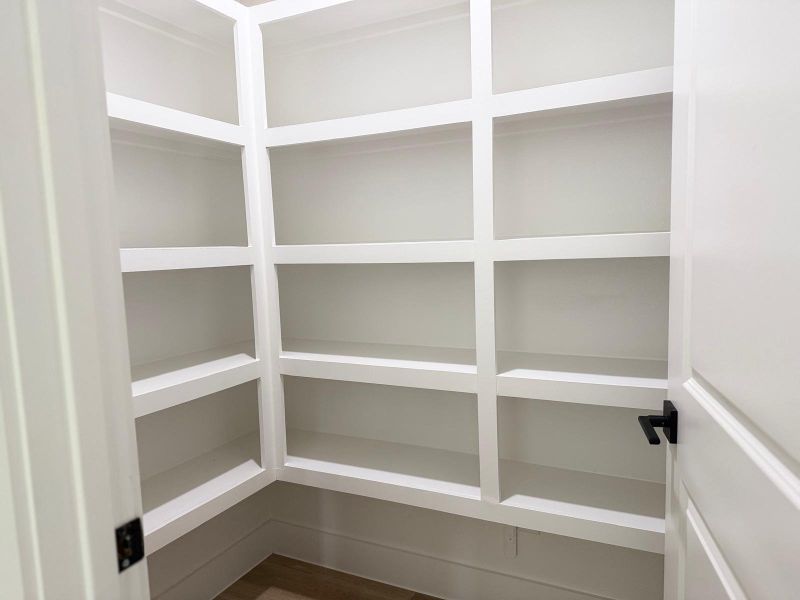 Spacious pantry with ample shelving for organized storage.