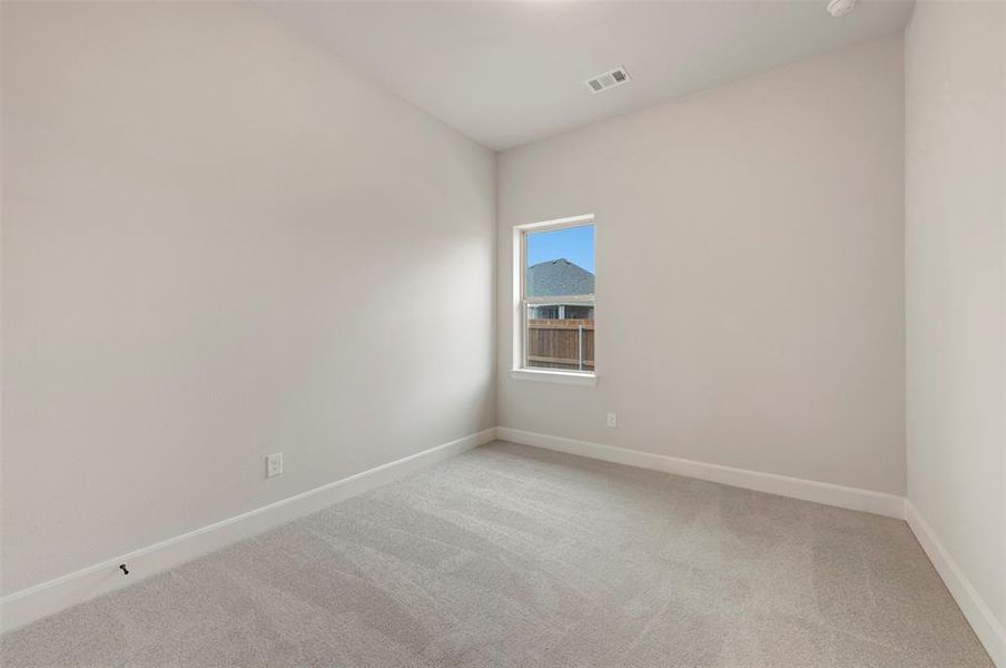 Unfurnished room featuring light carpet and baseboards