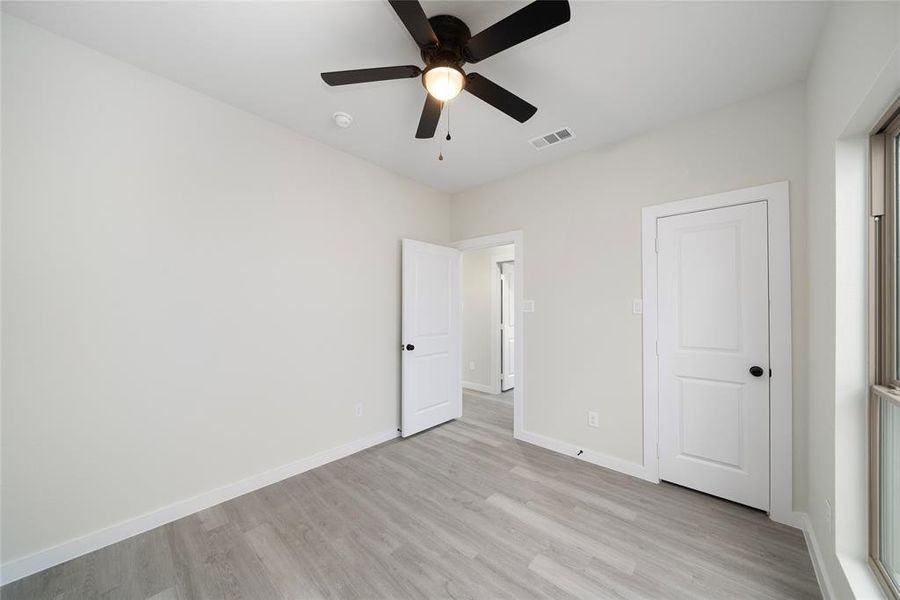 Unfurnished bedroom featuring ceiling fan and light wood-type flooring