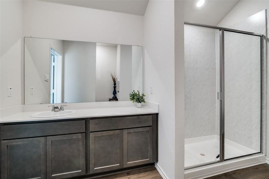 Full bath featuring a stall shower, vanity, and wood finished floors