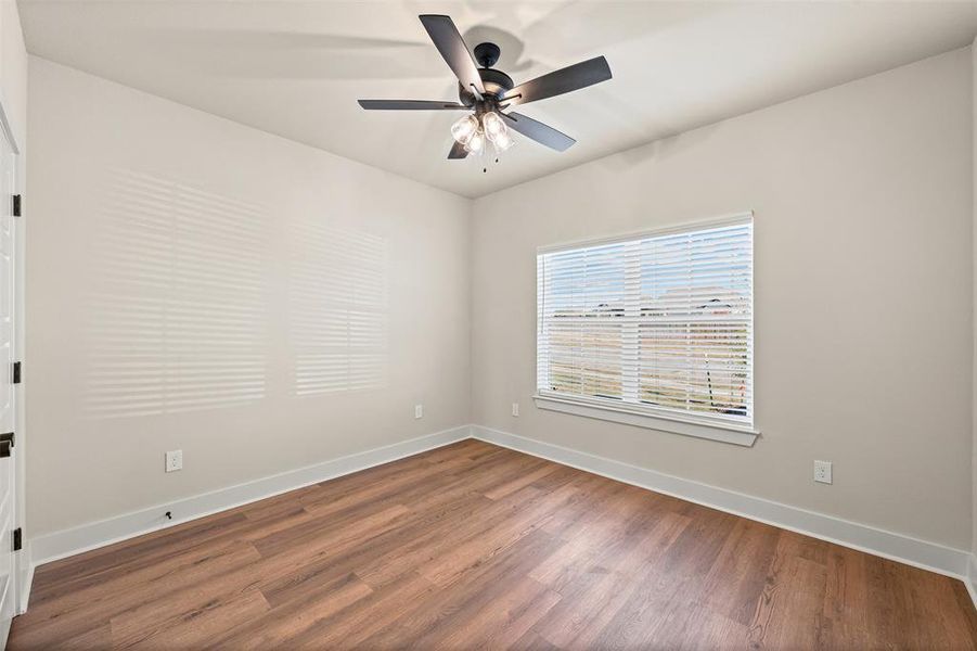 Empty room with wood finished floors and ceiling fan