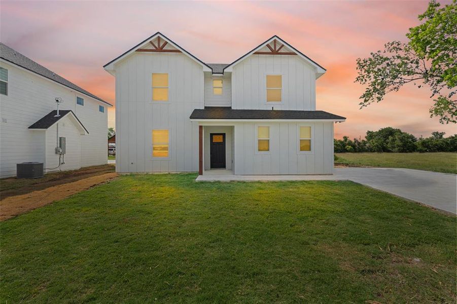 Modern farmhouse style home with board and batten siding and a front lawn Modern farmhouse style home with board and batten siding and a front lawn