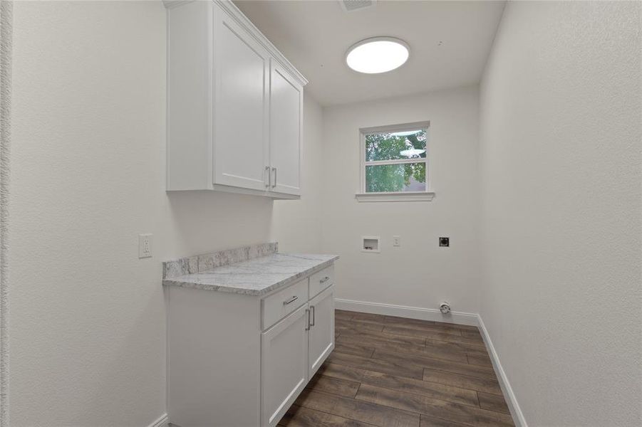 Utility space featuring white shaker cabinetry, a light-toned countertop, and wood-finish flooring Utility space featuring white shaker cabinetry, a light-toned countertop, and wood-finish flooring