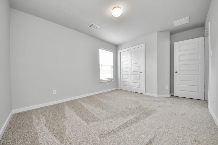 Generously sized secondary bedrooms featuring spacious closets, soft and inviting carpeting underfoot, large windows allowing plenty of natural light, and the added touch of privacy blinds for your personal retreat.