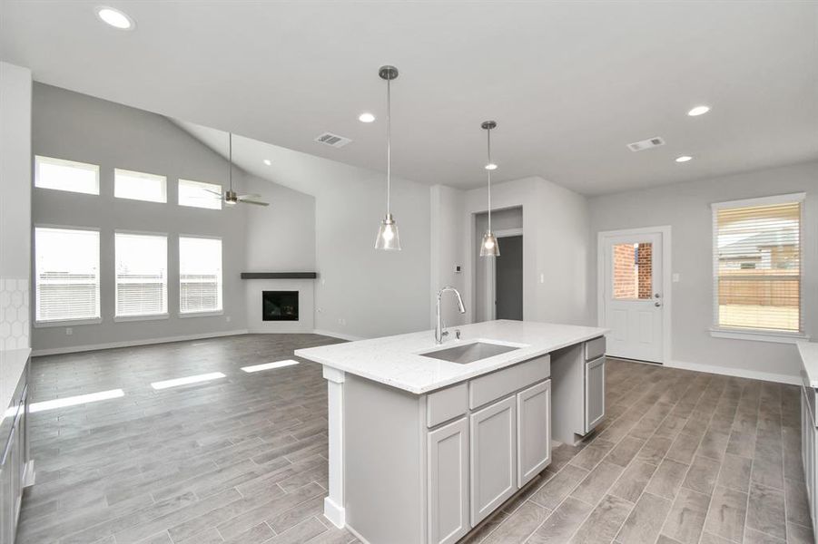 Discover another perspective of this stunning kitchen, generously appointed with an abundance of counter space. Sample photo of completed home with similar floor plan. As-built interior colors and selections may vary.