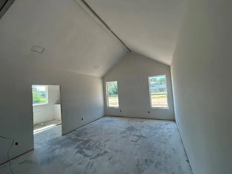 Spacious room featuring a vaulted ceiling and multiple windows providing ample ambient light Spacious room featuring a vaulted ceiling and multiple windows providing ample ambient light