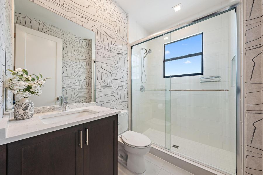 Upgraded shower, vanity, and custom wallpaper.
