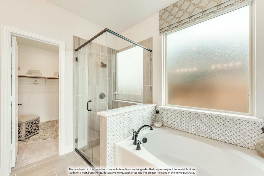 Master bathroom with soaking tub, glass walk-in shower, mosaic tile surround, and walk-in closet access