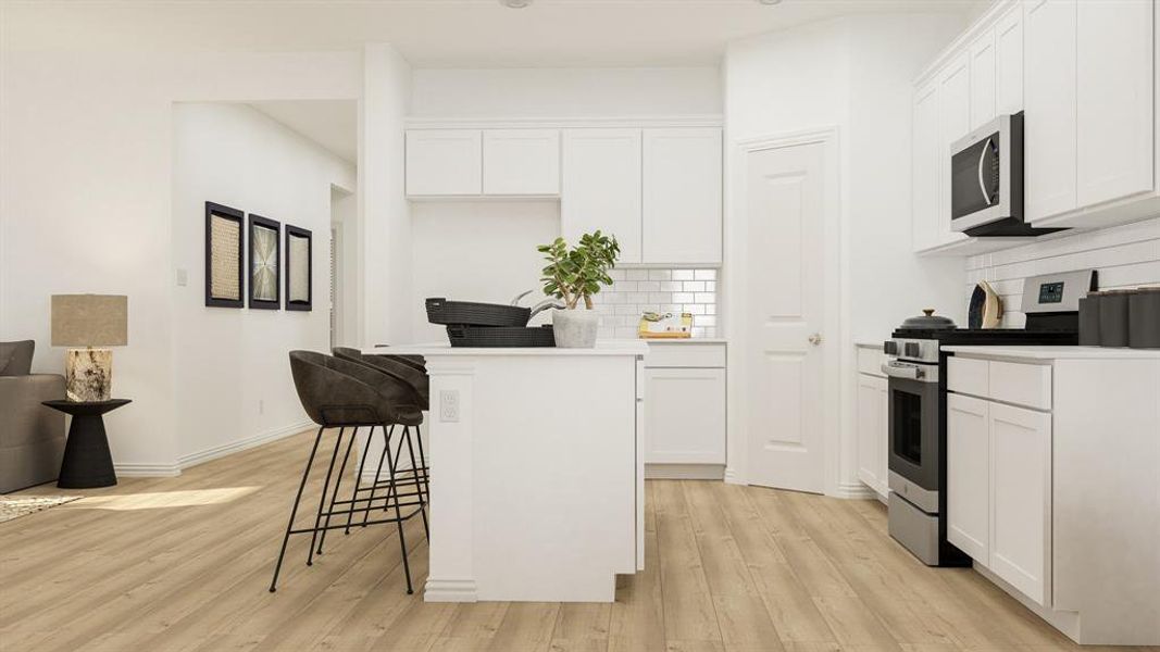 Kitchen featuring stainless steel appliances, decorative backsplash, and white cabinetry