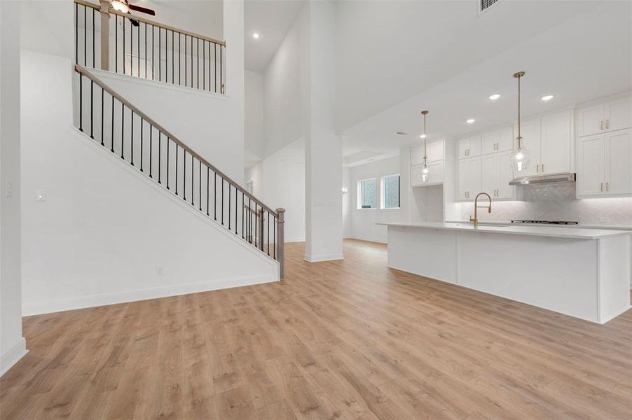 The open-concept interior features light wood-look flooring and white walls throughout