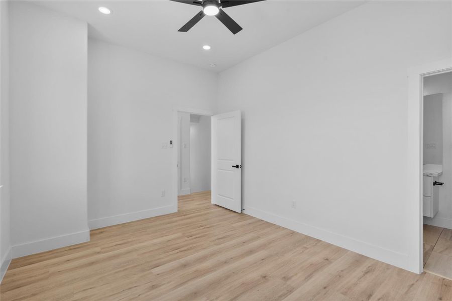 Bedroom suite featuring elevated ceilings, warm wood flooring and a serene contemporary atmosphere Bedroom suite featuring elevated ceilings, warm wood flooring and a serene contemporary atmosphere
