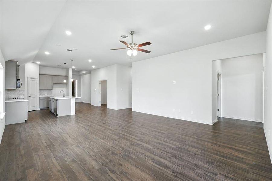 Unfurnished living room featuring recessed lighting, ceiling fan, and dark wood-type flooring Unfurnished living room featuring recessed lighting, ceiling fan, and dark wood-type flooring