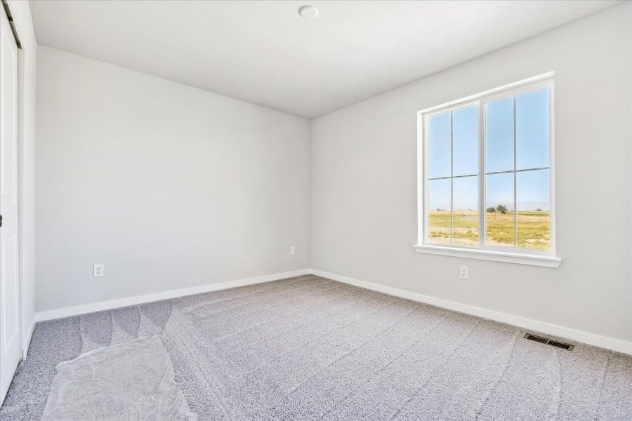 A room with a window and carpet.