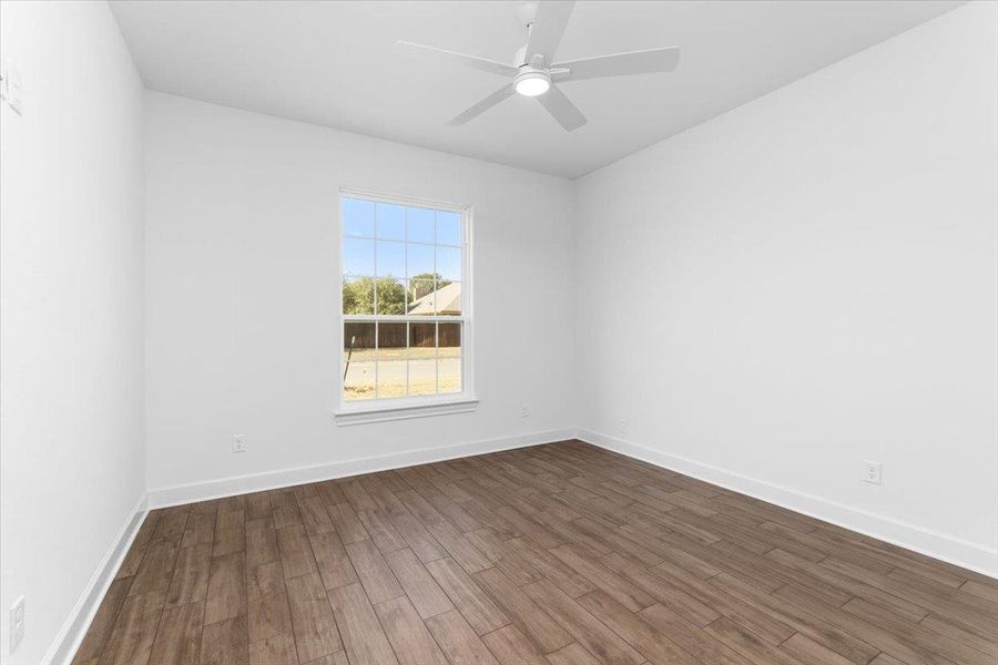 Spare room featuring dark wood finished floors, a ceiling fan, and baseboards Spare room featuring dark wood finished floors, a ceiling fan, and baseboards