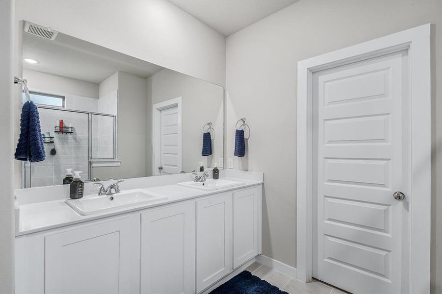 Bathroom with dual vanity and tile flooring