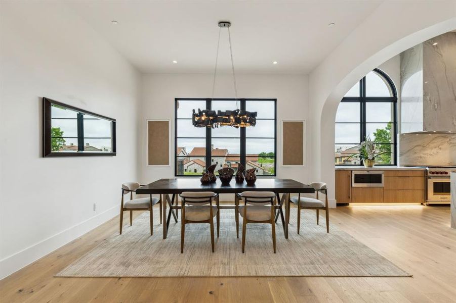Dining space featuring plenty of natural light, white oak wood floors, a designer lighting, and recessed lighting Dining space featuring plenty of natural light, white oak wood floors, a designer lighting, and recessed lighting
