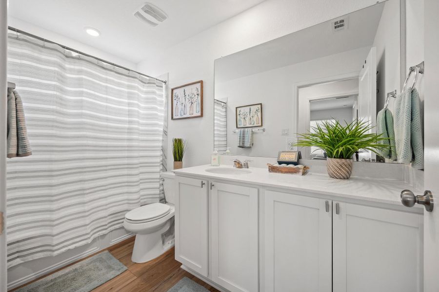 A well-lit 3rd bathroom features white cabinetry and a spacious quartz topped vanity. A well-lit 3rd bathroom features white cabinetry and a spacious quartz topped vanity.