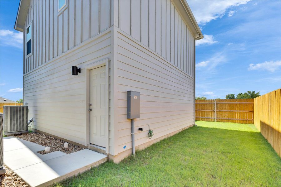 View of property exterior with board and batten siding and a fenced backyard View of property exterior with board and batten siding and a fenced backyard