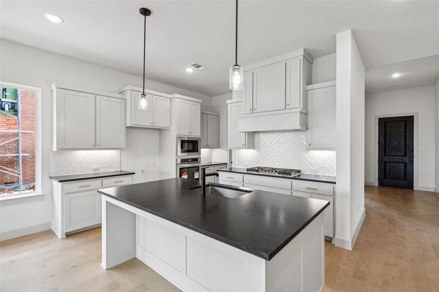 This dream kitchen offers gorgeous finishes in a classic black and white color scheme.