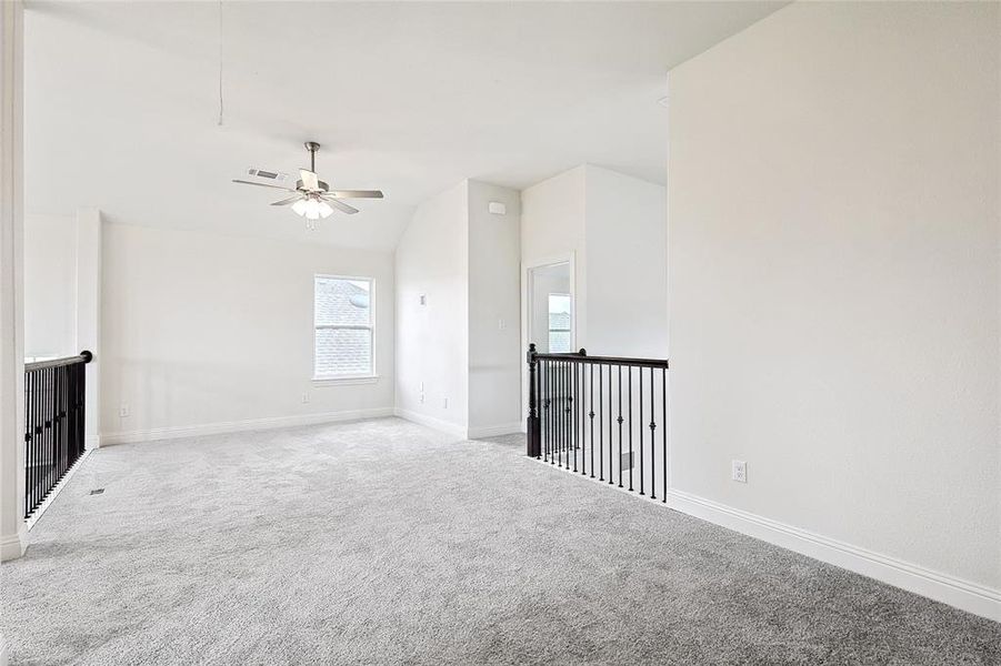 Carpeted spare room with vaulted ceiling and ceiling fan