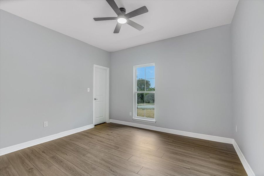 Unfurnished room with wood finished floors and a ceiling fan