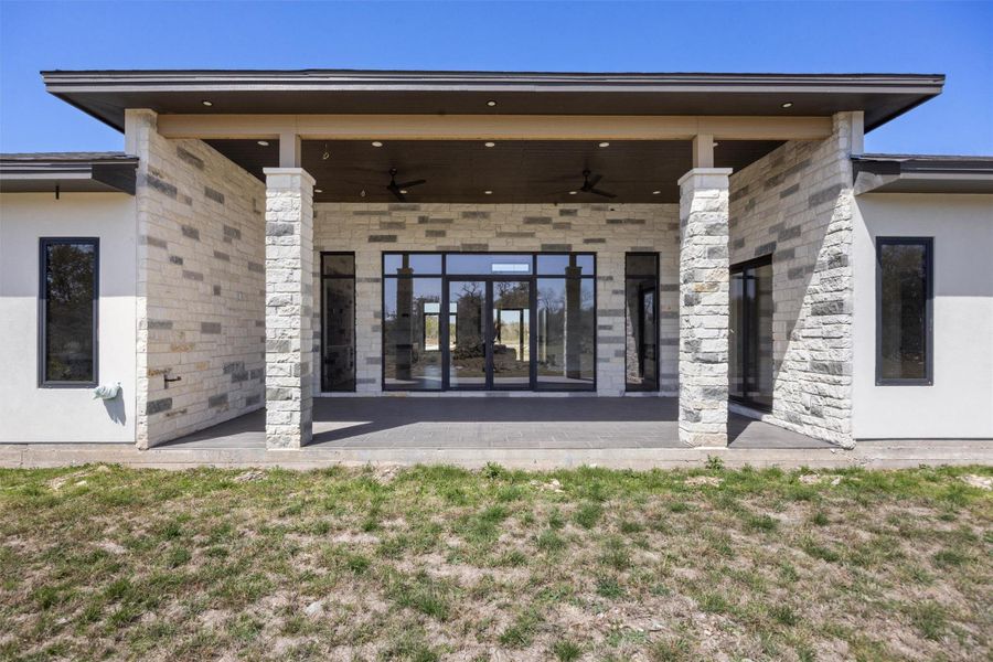 Back of property featuring stucco siding, a ceiling fan, and a patio