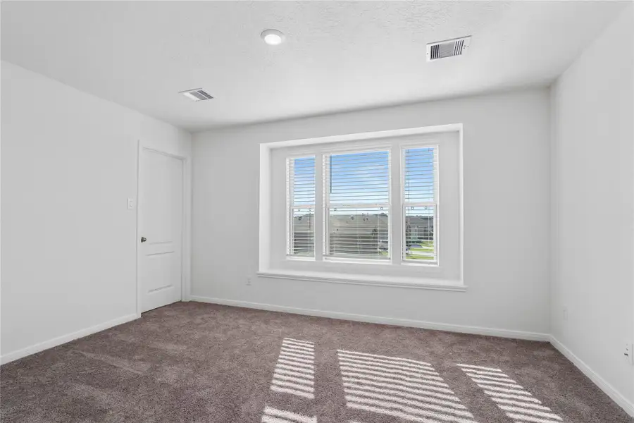 This secondary bedroom features the large picturesque window with blinds and a window shelf. It also features plush carpet flooring, neutral toned walls, recessed lighting, and a walk-in closet! This secondary bedroom features the large picturesque window with blinds and a window shelf. It also features plush carpet flooring, neutral toned walls, recessed lighting, and a walk-in closet!