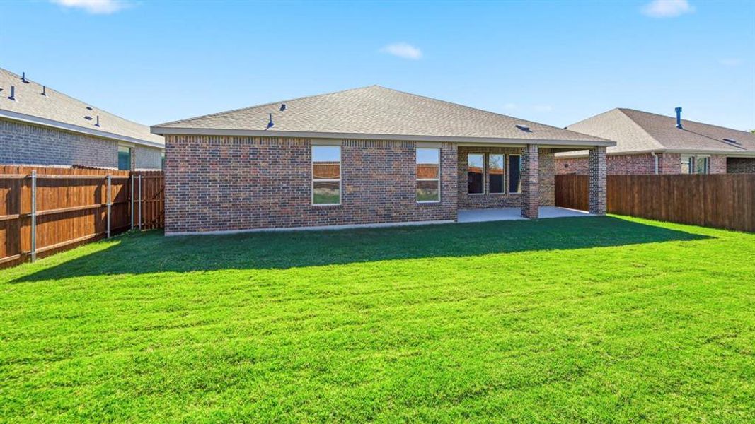 Rear view of house featuring brick siding, a fenced backyard, a patio, and roof with shingles Rear view of house featuring brick siding, a fenced backyard, a patio, and roof with shingles