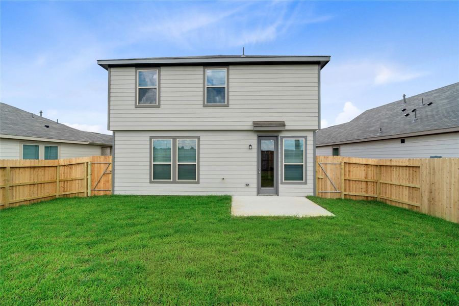 Spacious, fully fenced backyard featuring a concrete patio—a true blank canvas ready for your custom landscaping, patio furniture, or outdoor oasis.