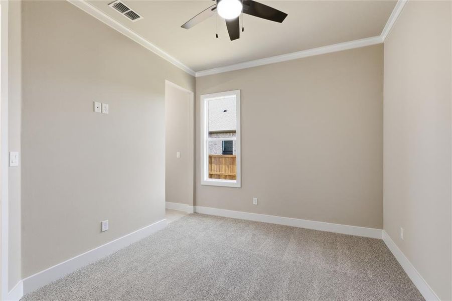 Carpeted room featuring a ceiling fan with integrated lighting, a single window, and crown molding